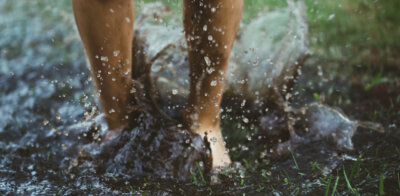 Barefoot jump into the muddy puddle